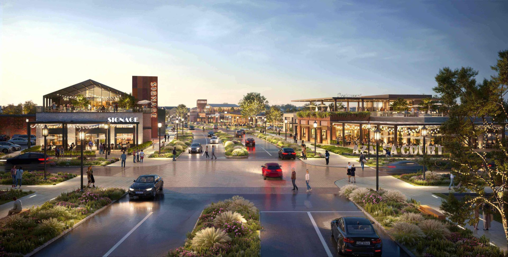 Azalea Court mixed-use retail and dining development at dusk with lit storefronts, rooftop patios, and tree-lined streets